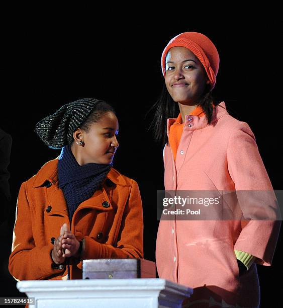 Malia and Sasha Obama attend the concert during the 90th National Christmas Tree Lighting Ceremony on the Ellipse behind the White House on December...