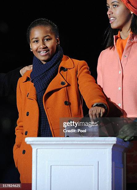 Malia and Sasha Obama light the 90th National Christmas Tree during the Lighting Ceremony on the Ellipse behind the White House on December 6, 2012...