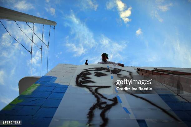 Artist known as Free Humanity works on his painting on the wall of a building as he participates in the Wynwood Walls art project on December 6, 2012...