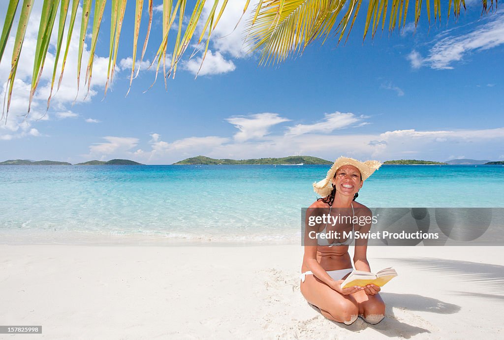 Happy woman on vacation beach reading book