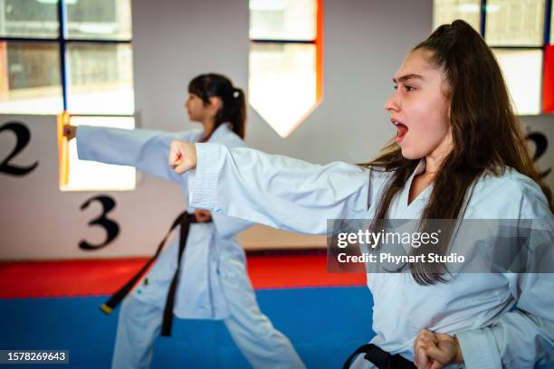 teenage girl training during a karate class - child punching stock pictures, royalty-free photos & images