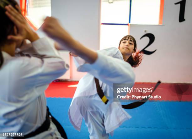 teenage girl training during a karate class - girl punching stock pictures, royalty-free photos & images