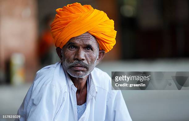 portrait of man in orange turban - turban stock pictures, royalty-free photos & images