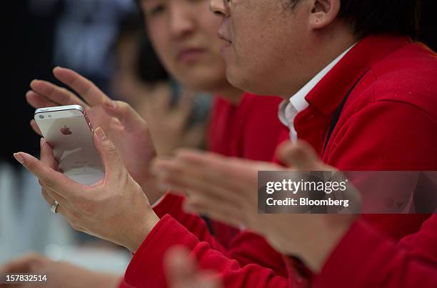 An SK Telecom Co. Employee holds an Apple Inc. IPhone 5 during a launch event in Seoul, South Korea, on Friday, Dec. 7, 2012. The iPhone 5 went on...
