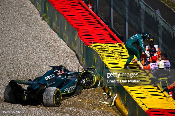 Lance Stroll of Canada and Aston Martin F1 Team climbs from his car after crashing during the Sprint Shootout ahead of the F1 Grand Prix of Belgium...