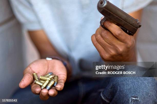 Young gang member shows a gun and ammunition, in Bonteheuwel neighborhood in Cape Town, on November 17, 2012. The sandy, windswept Cape Flats is home...