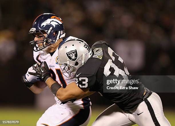 Joel Dreessen of the Denver Broncos is tackled by Tyvon Branch of the Oakland Raiders at O.co Coliseum on December 6, 2012 in Oakland, California.