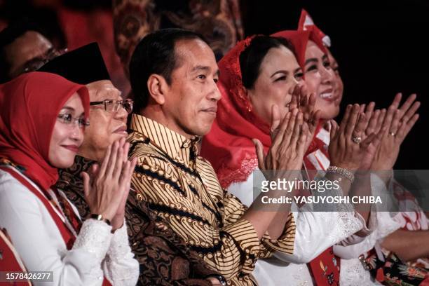 Indonesian President Joko Widodo react before players of Indonesia's traditional bamboo musical instruments "angklung" achieve the new Guinness World...