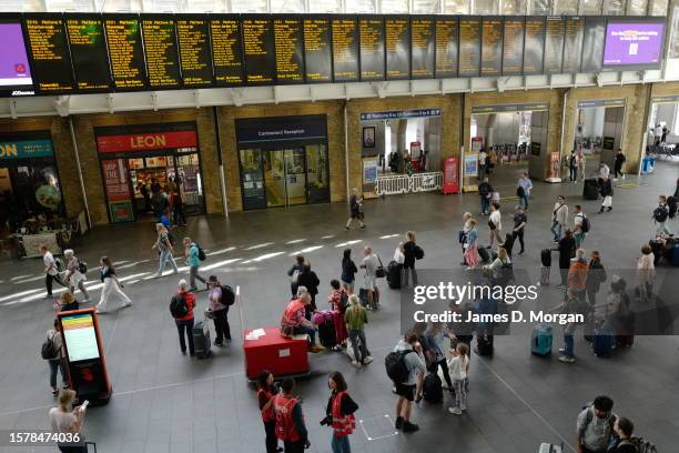 Passengers wait for announcements for the few services departing Kings Cross Station on July 29, 2023 in London, England. 20,000 rail workers...