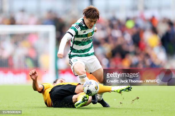 Kyogo Furuhashi of Celtic is challenged by Craig Dawson of Wolverhampton Wanderers during the pre-season friendly match between Celtic and...