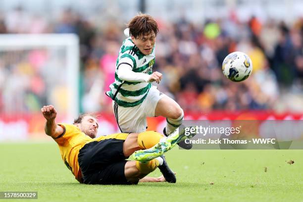 Kyogo Furuhashi of Celtic is challenged by Craig Dawson of Wolverhampton Wanderers during the pre-season friendly match between Celtic and...