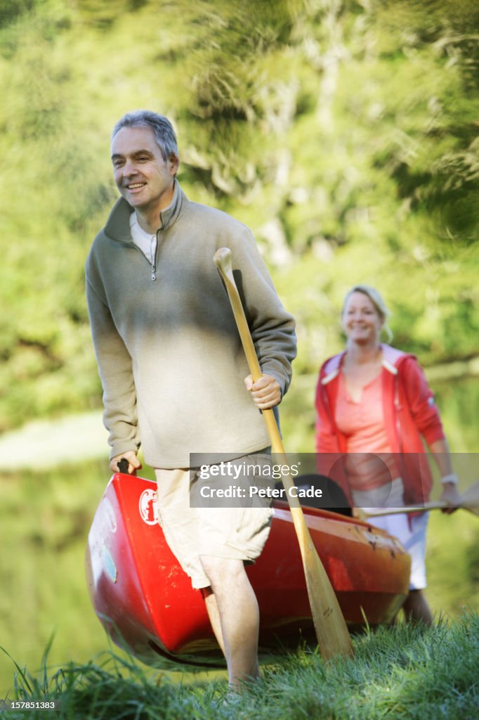 Couple taking canoe out of water