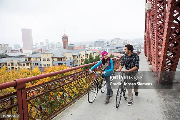 friends walking with thier bikes in autumn. - portland oregon stock pictures, royalty-free photos & images