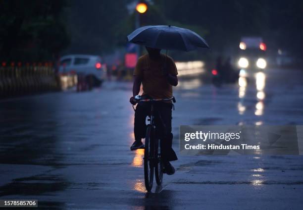 Commuters seen out during early morning light rain at Sector 22 road, on August 5, 2023 in Noida, India.