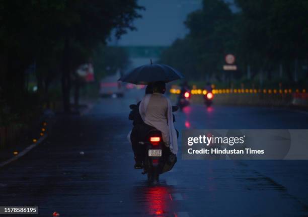 Commuters seen out during early morning light rain at Sector 22 road, on August 5, 2023 in Noida, India.