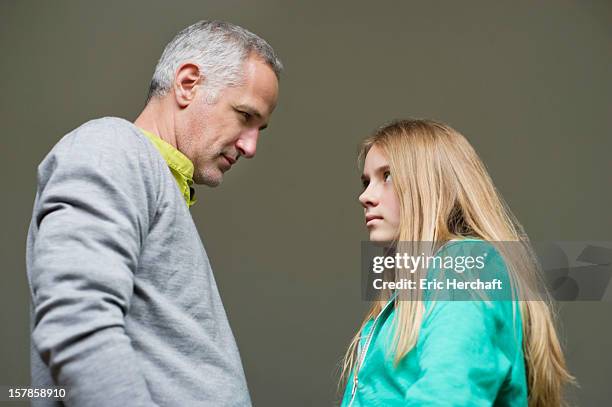 man and daughter frowning to each other - dispute stock-fotos und bilder