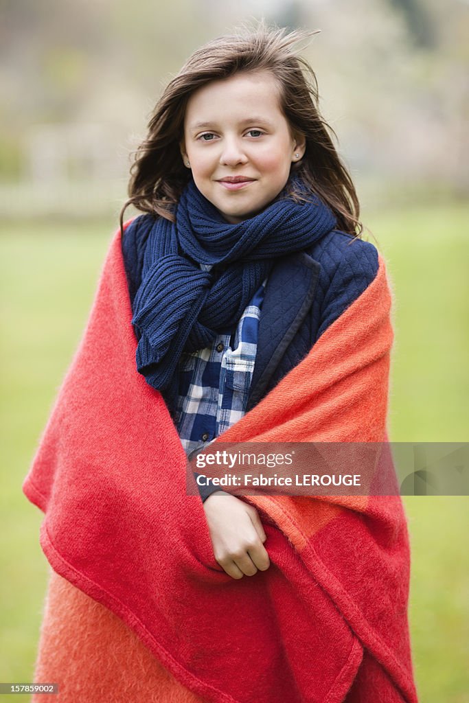 Portrait of a girl wrapped in a blanket and smiling