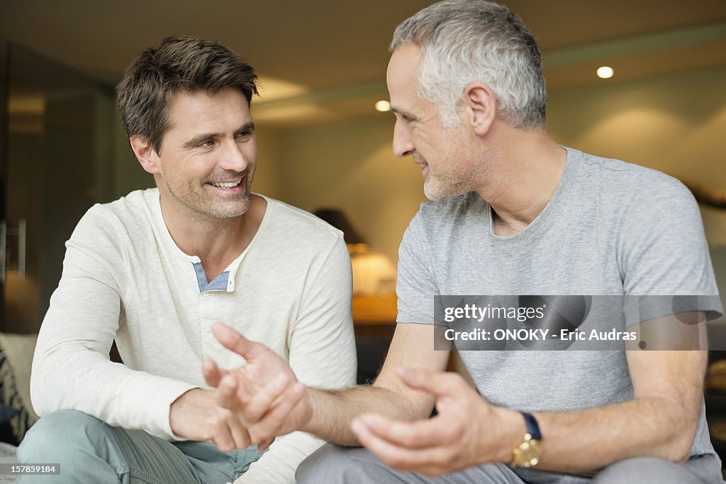 Two male friends discussing and smiling