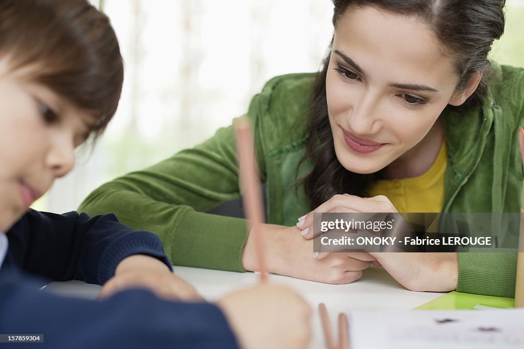 Woman teaching her son at home