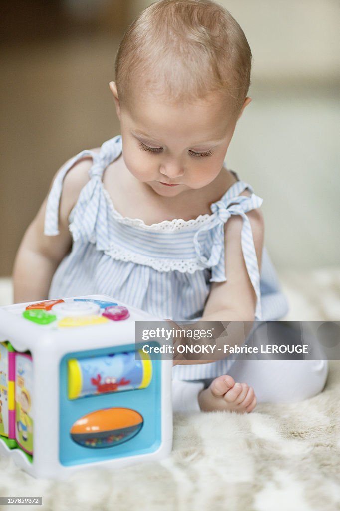 Baby girl playing with a musical block toy