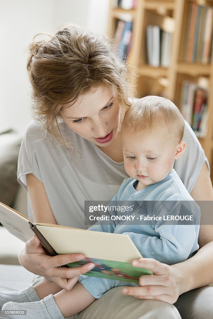 Woman teaching her daughter from a picture book