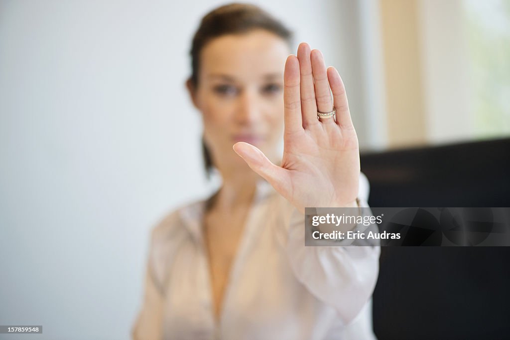 Businesswoman showing her wedding ring with stop gesture