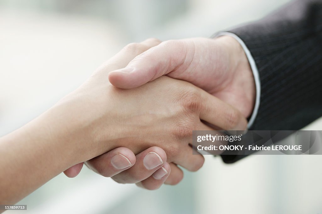 Close-up of business executives shaking hands in an office