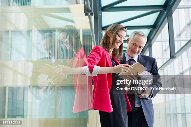 business executives discussing in an office corridor - secretary stock pictures, royalty-free photos & images