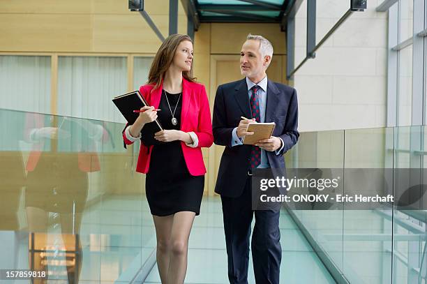 business executives discussing in an office corridor - man check suit stock pictures, royalty-free photos & images