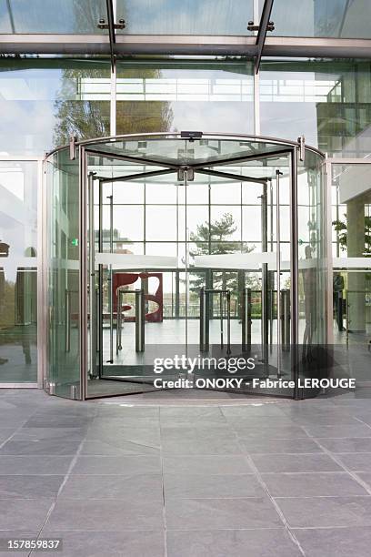 revolving door of an office building - building entrance stock pictures, royalty-free photos & images