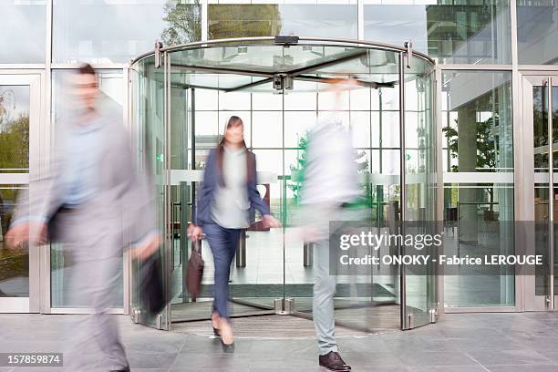 business executives at entrance of an office building - office building entrance people stock pictures, royalty-free photos & images