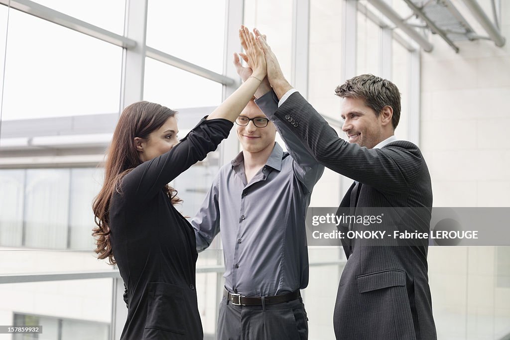 Business executives giving high-five to each other