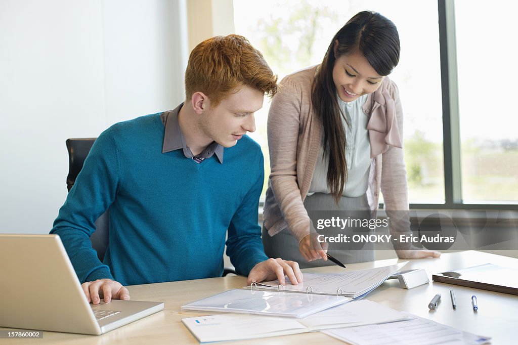 Businessman examining documents with his secretary