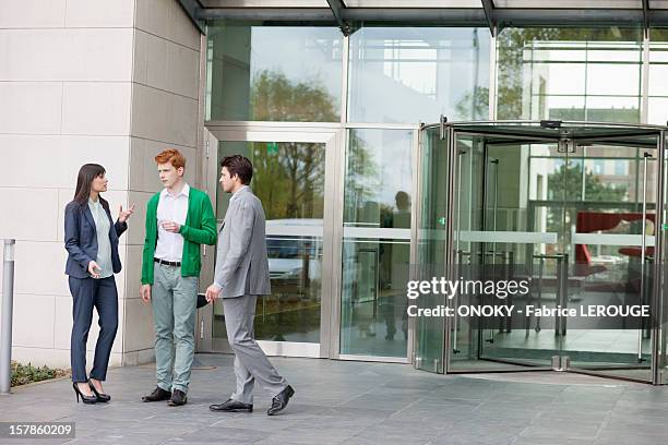 business executives smoking in front of an office building - タバコを吸う ストックフォトと画像