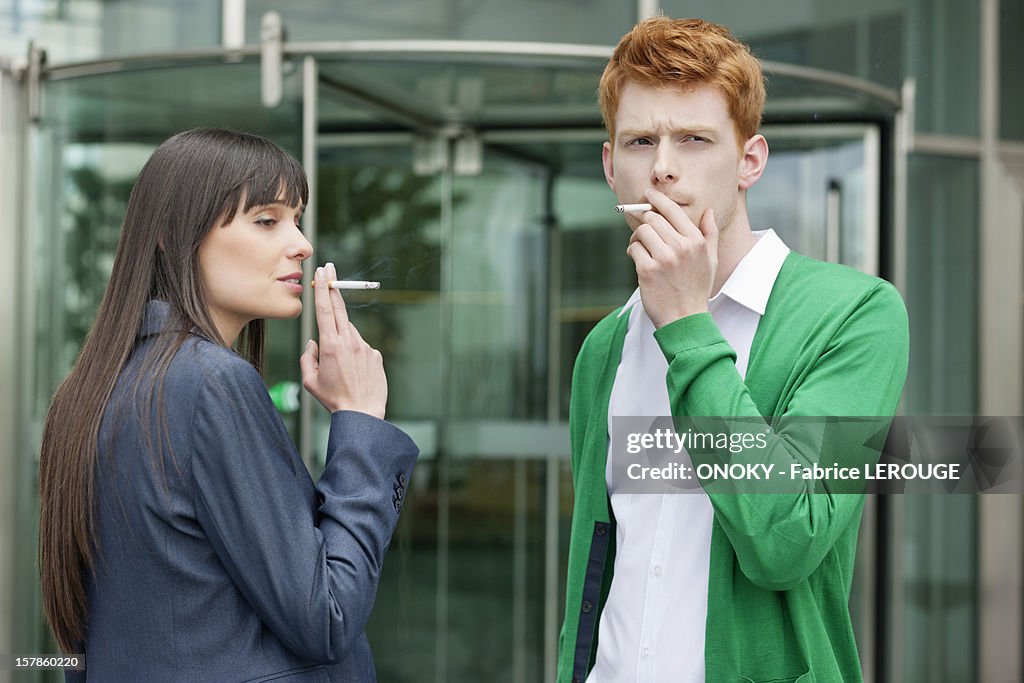 Business executives smoking in front of an office building