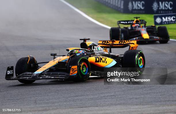 Oscar Piastri of Australia driving the McLaren MCL60 Mercedes leads Max Verstappen of the Netherlands driving the Oracle Red Bull Racing RB19 during...