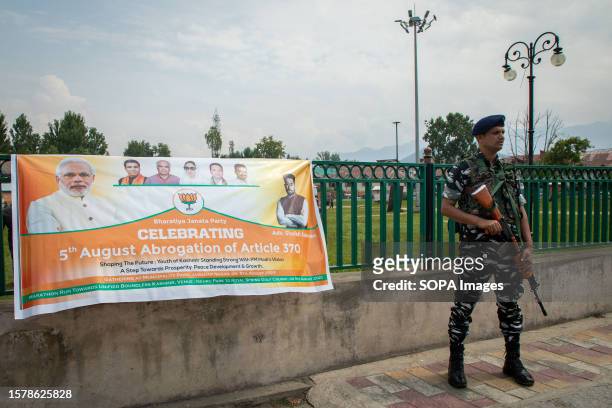 Indian paramilitary trooper stands on guard outside the venue as supporters of the Bharatiya Janata Party celebrate the fourth anniversary of the...