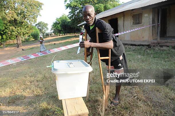 Man on crutches poses before casting his vote at Talekura, Bole Bamboi constituency, in a northern region on December 7, 2012 as Ghana voted in a...