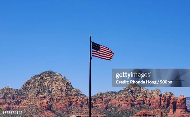 low angle view of american flag waving against clear blue sky,sedona,arizona,united states,usa - sightseeing in sedona stock pictures, royalty-free photos & images