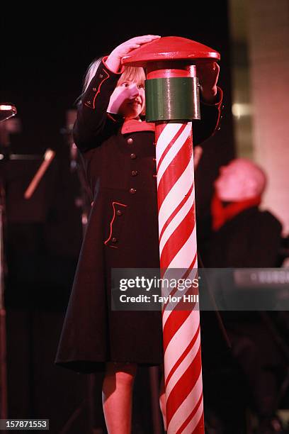 Nine-year-old Abigail Simmons hits the button that lights the tree at The Metropolitan Opera Tree Lighting Ceremony at The Metropolitan Opera House...