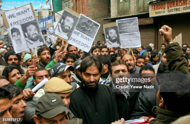 Yasin Malik , chairman of the JKLF and his supporters carry a banners during a protest against a court verdict sentencing of two Kashmiris to life...