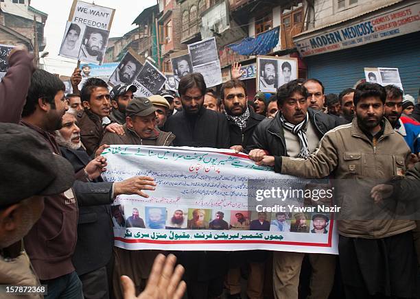 Yasin Malik , chairman of the JKLF and his supporters carry a banners during a protest against a court verdict sentencing of two Kashmiris to life...