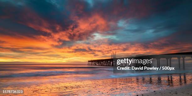 silhouette of bridge over sea against sky during sunset,lowestoft,united kingdom,uk - suffolk england imagens e fotografias de stock