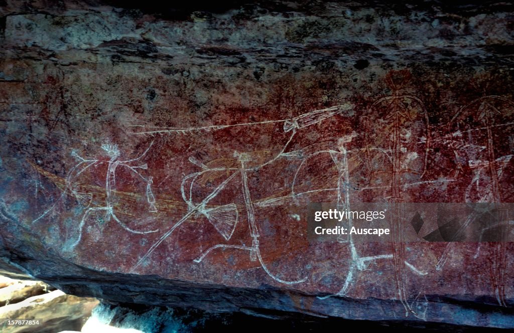 Aboriginal rock art: running men wearing head decorations and elbow ornaments, carrying double-pronged spears, woomeras (spear throwers), stone axes, string dilly bags and goose-feather fans