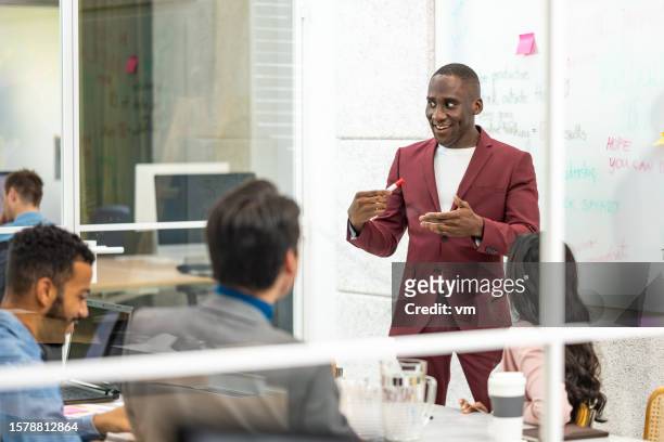 african american project management coach explaining brainstorming and time management technique in conference room - agile business stockfoto's en -beelden