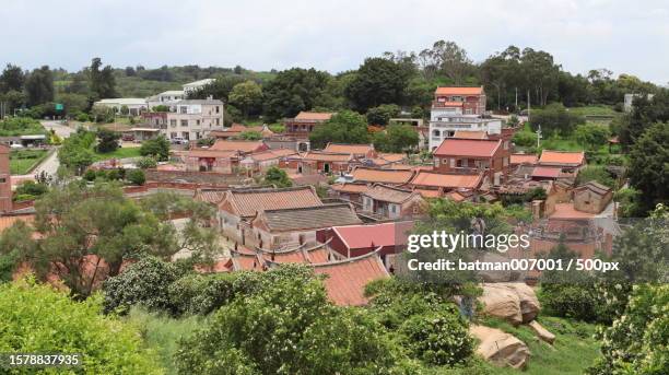 high angle view of couple standing on the rock looking at townscape against sky - the batman stock pictures, royalty-free photos & images