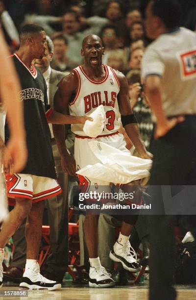 As teammate Scottie Pippen holds him back, guard Michael Jordan of the Chicago Bulls has words for referee Hugh Hollins, foreground, who called a...