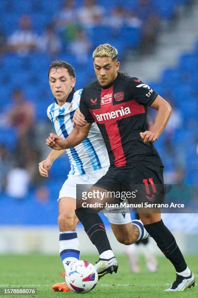 Nadiem Amiri of Bayer 04 Leverkusen duels for the ball with Jon Ander Olasagasti of Real Sociedad during the pre-season friendly match between Real...
