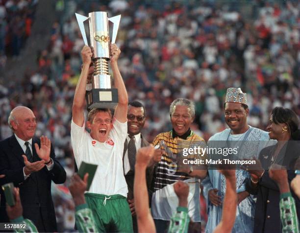 The captain of the winners of the African Cup of Nations Final Neil Tovey of South Africa holds the cup aloft after President Mandela presented it to...
