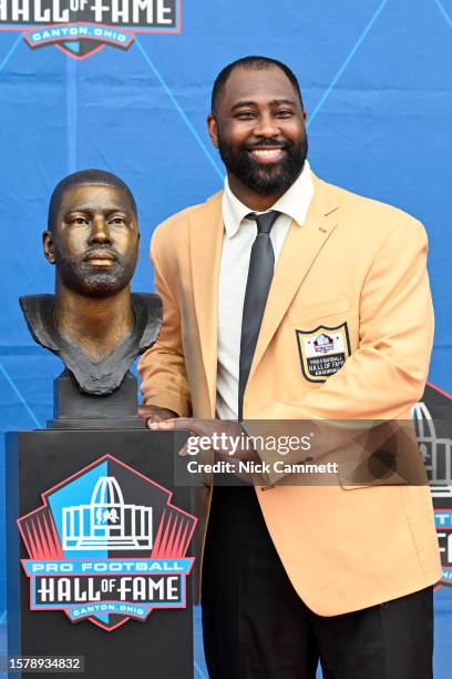 Darrelle Revis poses with his bronze bust during the 2023 Pro Football Hall of Fame Enshrinement Ceremony at Tom Benson Hall Of Fame Stadium on...